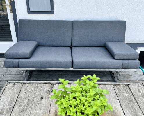 Sofa in Cast Charcoal with two strapped on arm rest cushions; 4" seats, 3" backs and arm rests; all foam-filled.