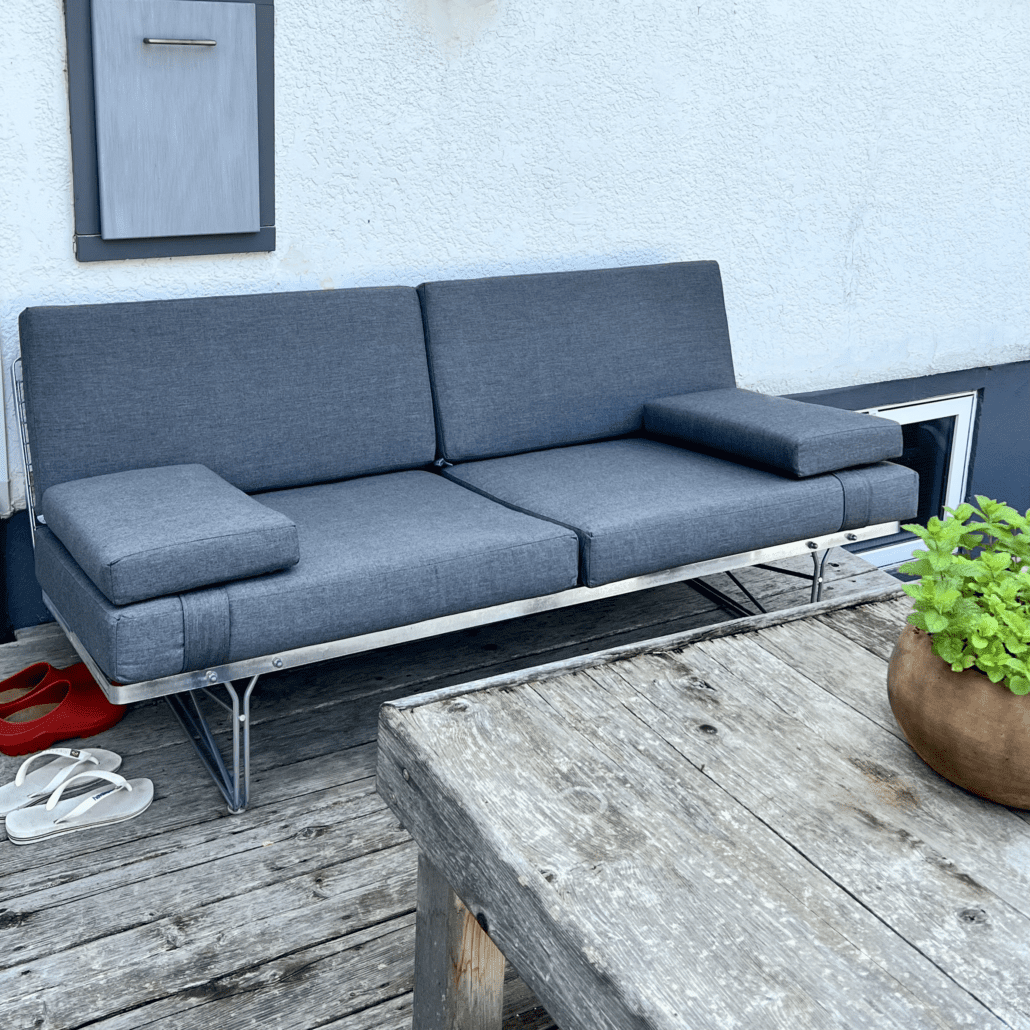 Sofa in Cast Charcoal with two strapped on arm rest cushions; 4" seats, 3" backs and arm rests; all foam-filled.
